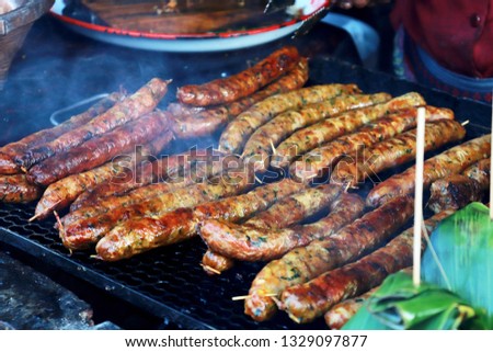 Grilling Thai sausages on barbecue grill. BBQ in the garden. Bavarian sausages.