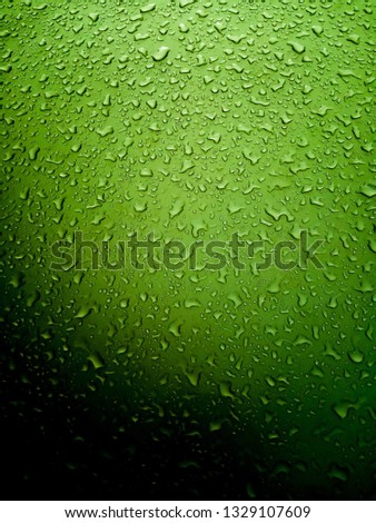 Picturesque drops of water or other liquid on a smooth glossy surface. Colorful decrease in illumination to the bottom edge. Beautiful color shades.