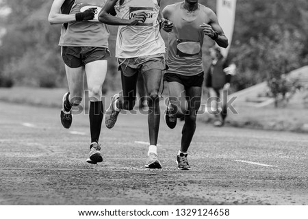 leading group of athletes runners running marathon black-and-white image