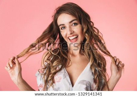 Image of positive lady 20s wearing dress smiling and looking at you, isolated over pink background