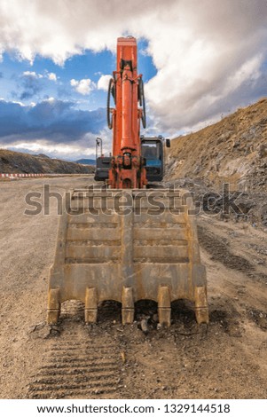 Excavator building a road next to a slope