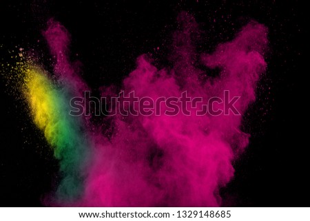 Color powder explosion cloud on black background. Freeze motion of pink color dust  particles splashing.