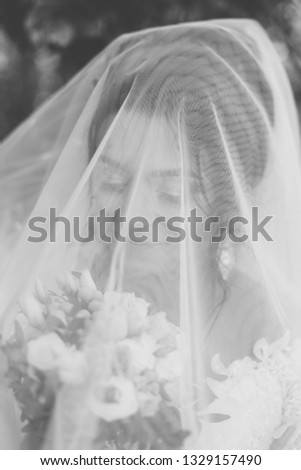 Very beautiful bride is holding a bouquet.