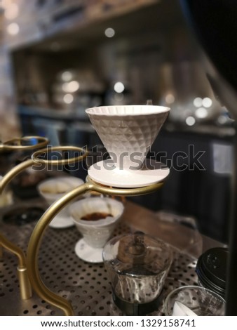 A barista coffee equipment to brew out an aroma coffee with a lot of accessories including drop coffee, water bowl, cup, coffee filter in the kitchen area. 