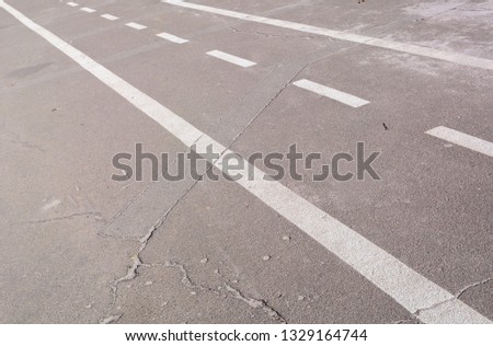 White diagonal lines on asphalt. Road marking and old road