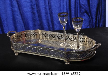 Silver salver on a blue background with 2 wine glasses Royalty-Free Stock Photo #1329165599