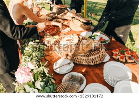 People take delicous salty snacks from the table arranged in Italian style