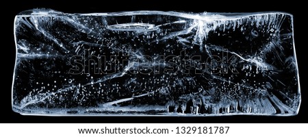 Large rectangle of clear ice with bubbles, on black. Creative concept photo of large rectangle of clear pure cool cold frozen water ice with bubbles on black background.
