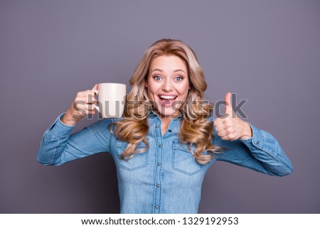 Close-up portrait of nice cute lovely fascinating charming attractive cheerful optimistic well-groomed wavy-haired lady wearing blue shirt drinking latte showing thumbup isolated over gray  background