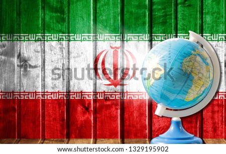 Globe with a world map on a wooden background with the image of the flag of Iran. The concept of travel and leisure abroad.