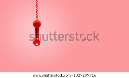 Red old telephone receiver hanging on pink background with texting space, waiting for phone call, vintage telephone.  Royalty-Free Stock Photo #1329199916