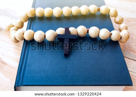 Top view of closed holy bible lying on wooden surface . Holy Bible book . Wooden crucifix