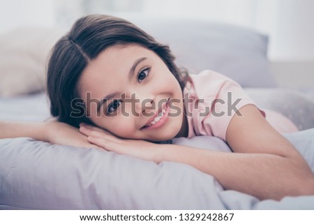 Close up photo cute sweet beautiful she her little girl lying down on pillow hands arms hold head homey sunday mood wear home t-shirt pants comfortable apartments flat bright light colored room
