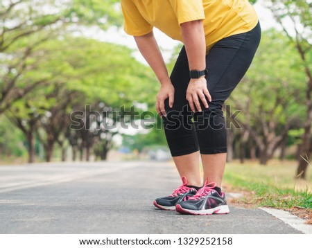 Overweight woman feeling tired while running in the park. Weight loss concept Royalty-Free Stock Photo #1329252158