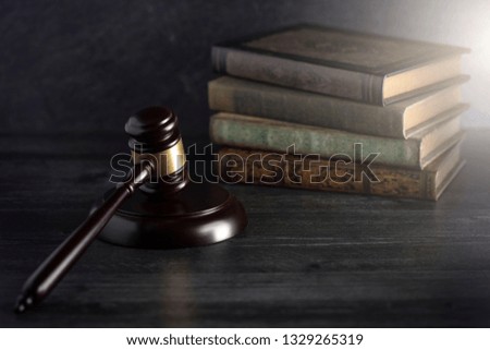 Wooden Judges Gavel on a Desk with Books in the Background