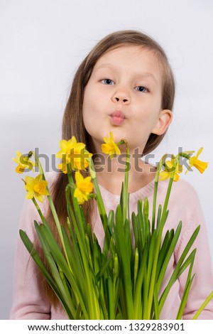 Little girl with a bouquet of yellow daffodils