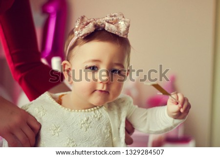 1 year baby girl in pink dress with her first birthday cake, happy birthday card,a cute little girl celebrates her first birthday surrounded by gifts