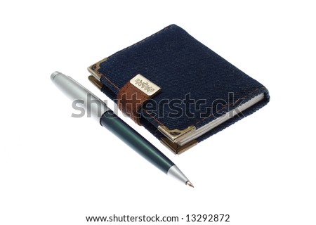 The closed notebook and ball pen on a white background