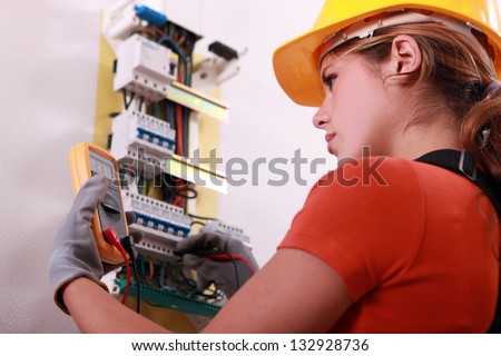 Woman measuring electrical current Royalty-Free Stock Photo #132928736