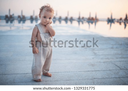 A small toddler girl standing on beach on summer holiday. Copy space.