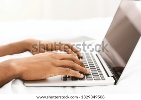 African-american blogger typing on laptop, chatting with followers, preparing trendy content, closeup