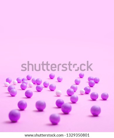 Pink and white small balls are scattered abstractly on the pink surface