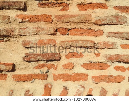 Traditional orange bricks wall of a medieval church in Haute-Garonne, Occitanie, south France. Background, grunge and texture photography. Backdrop for exterior or interior design