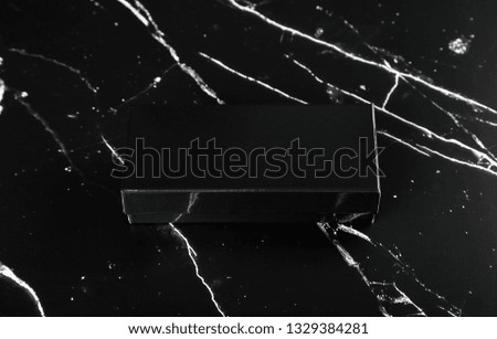 Photo of black glossy box on black marble. Template for branding identity isolated on marble background. For graphic designers presentations and portfolios marble premium luxury mock-up. 