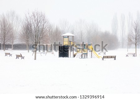 Children's playground covered with snow in winter, Milano, Italy