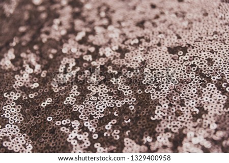 Brown shiny fabric with sequins, abstract background.