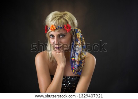portrait of beautiful young blonde woman wearing hippie headband on black background