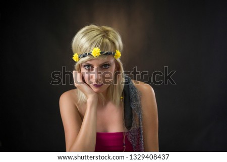 portrait of beautiful young blonde woman wearing hippie headband on black background