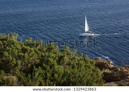 cruise vacation concept photography of small white yacht aerial view near Mediterranean waterfront from above on calm blue water surface wallpaper pattern with empty copy space for your text