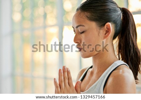 Focused young woman meditating while practicing yoga.