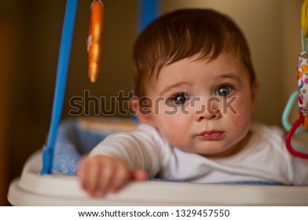 Portrait of a young baby sitting in a high chair.