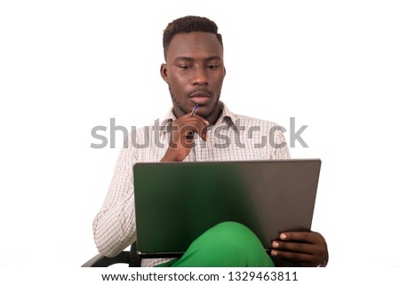 young man sitting in a chair looking at laptop.