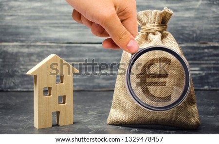 Money bag with euro sign and wooden house. The concept of real estate investing. The accumulation of money to buy a home. Rent apartment. Payment of mortgage interest. Debt repayment. Save money