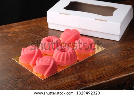 six assorted mousse cakes near white cake box on wooden table
