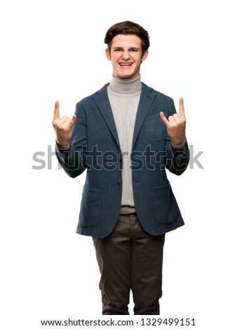 Teenager man with turtleneck making rock gesture over isolated white background