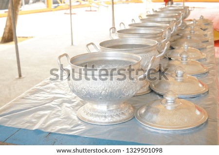 
Thai style aluminum rice bowl sort deep rows on table. Scoop the rice into the bowl to give alms to a Buddhist monk