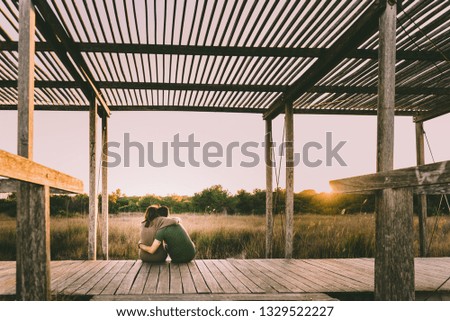 Couple hugging each other in love while they relax watching the nature at sunset.