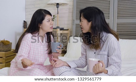asian girls cannot handle pressure feeling miserable and sad. Gloomy women sitting in nightwear on bed complaining on life together. young korean ladies gossip about dumb thing happened yesterday. Royalty-Free Stock Photo #1329561779