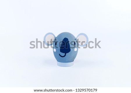 Easter holiday concept with cute handmade eggs. Gray koala on solid background