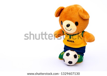 Teddy bear athlete in Brazil dressed player with ball isolated on white background.