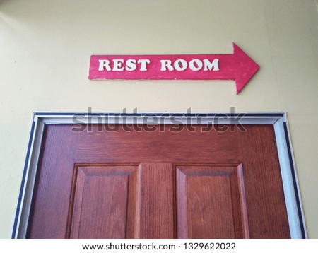Sign way to a rest room  at the wood door.