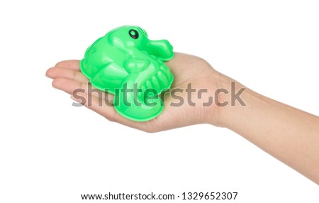 hand holding plastic sea horse of beach toy isolated on white background