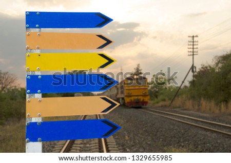 Beautiful colored direction signs with train background