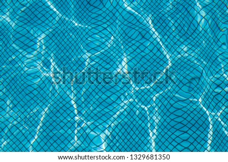 Hotel swimming pool with sunny reflections.Ripple Water in swimming pool with sun reflection. Blue swimming pool rippled water.swimming, pool, waves under sun light. Trendy colors 2020, aqua menthe
