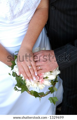 wedding couples hands over flowers