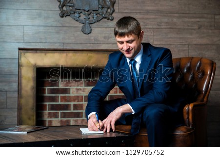 Businessman, lawyer, a man in business suit and tie is sitting at coffee table in office and stating the signature on the documents, make a contract